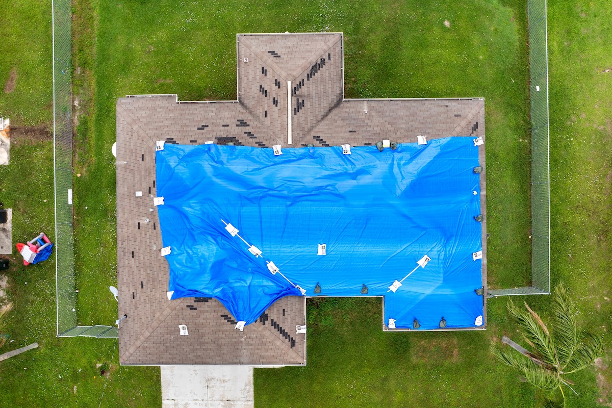 Emergency Roof Tarping and Leak Mitigation - Tarp on top of a roof